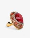 Red statement ring featuring a rich faceted stone surrounded by crystals and a Gold tone finish.