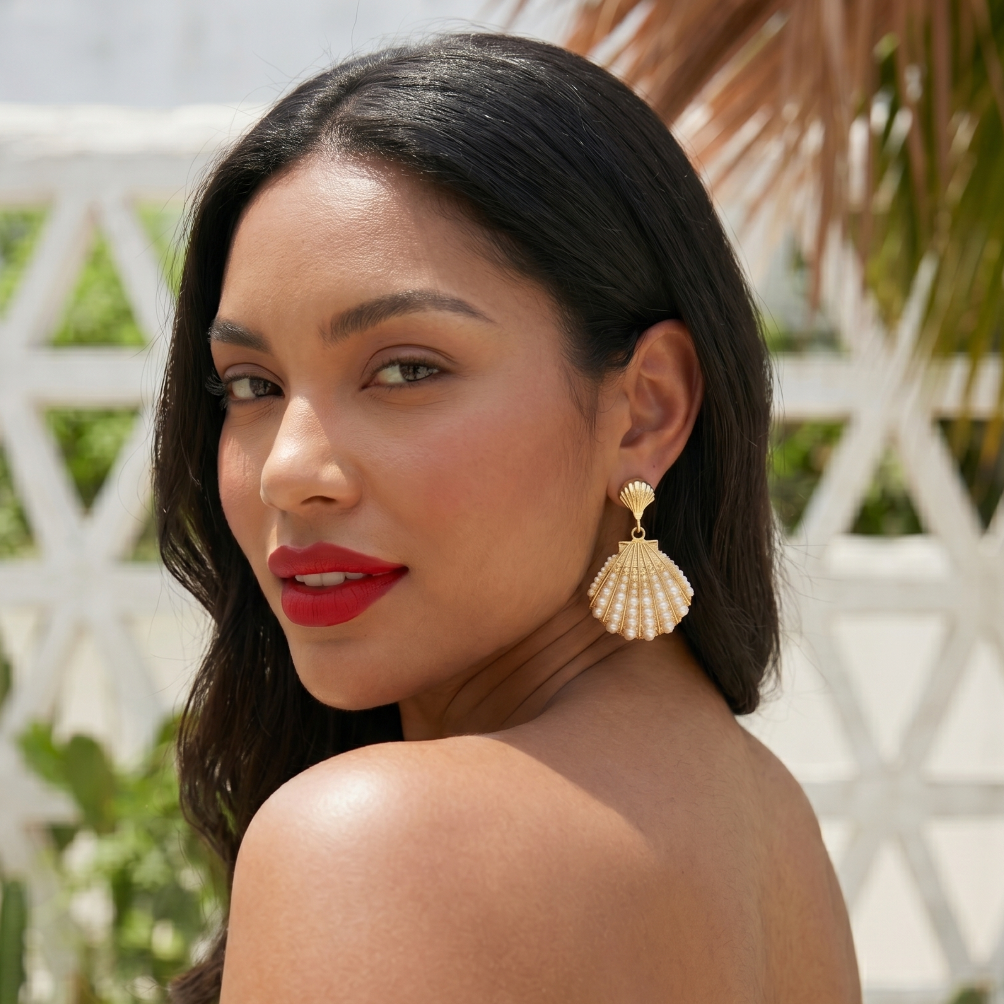 Gold shell dangle earrings featuring luminous pearl embellishments and coastal-inspired detailing by Sassy Jones.