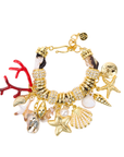 Statement charm bracelet featuring coral accents, starfish charms, seashell details, pearl embellishments, pavé crystal accents, and gold-tone hardware by Sassy Jones.