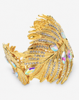 Tropical statement bracelet featuring a wide gold palm leaf silhouette embellished with rows of clear crystals.