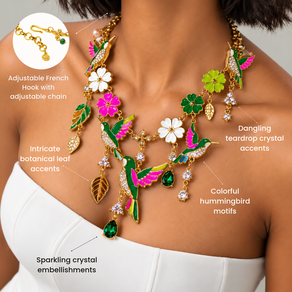 Gold statement necklace featuring three colorful hummingbirds, dangling crystal accents and delicate botanical charms.