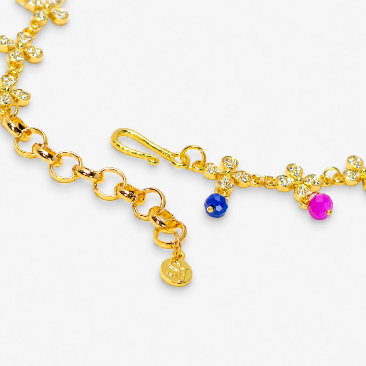 Cherish Hummingbird 18k Garden Necklace displayed flat featuring colorful enamel birds, floral charms and an adjustable gold chain.