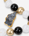 Black and gold statement necklace featuring chunky round beads and an organic raw agate centerpiece.