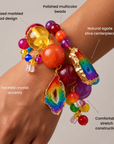 Multicolor bracelet stack featuring red, yellow, orange, purple, and rainbow beads with natural agate accents.
