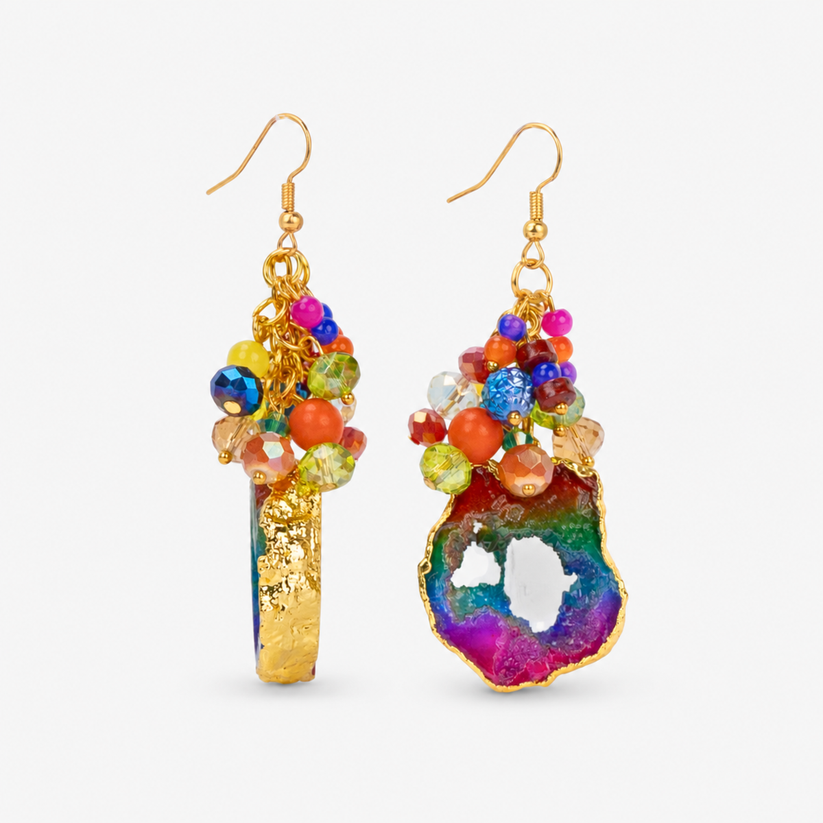 Chrysallis Joyride earrings featuring organically shaped rainbow agate pendants surrounded by vibrant bead clusters.
Colorful natural stone dangle earrings with blue, green, purple, orange, pink, and yellow accents.

Close-up of Chrysallis Joyride statement earrings featuring unique rainbow agate slices with Gold tone finish edging.

Rainbow gemstone earrings featuring natural agate drops and playful multicolor faceted bead clusters.