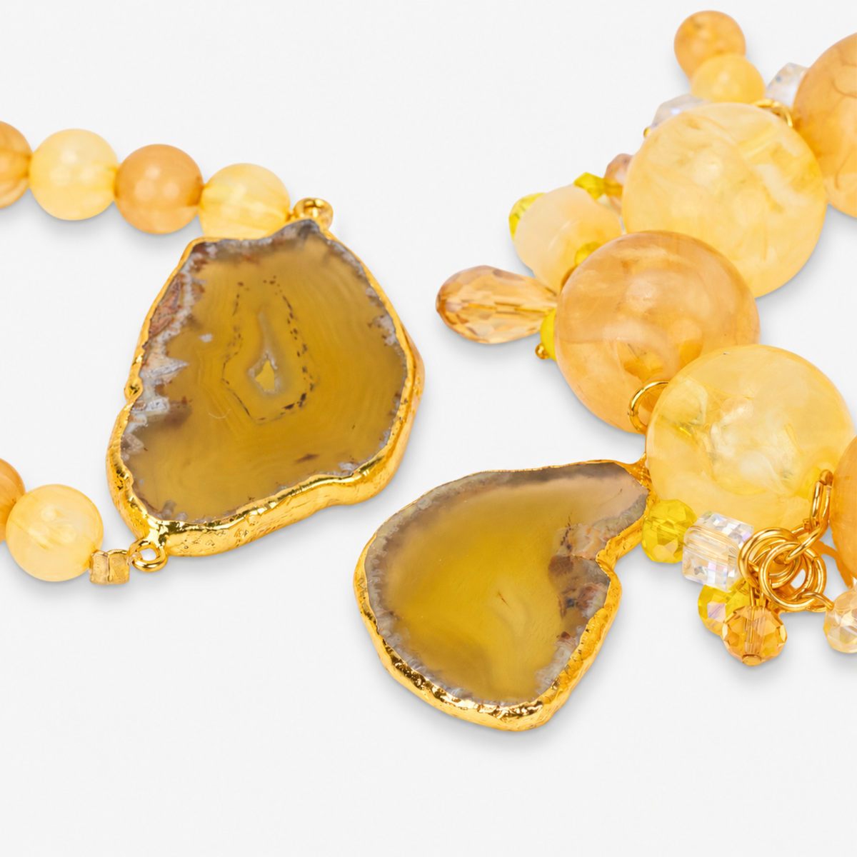 Close-up of Chrysallis Lemon Sorbet bracelets with marbled beads, faceted accents, dangling charms, and sliced agate.


1. Chunky yellow bracelet stack featuring natural stone variations, citrus colored beads, and decorative hanging accents.