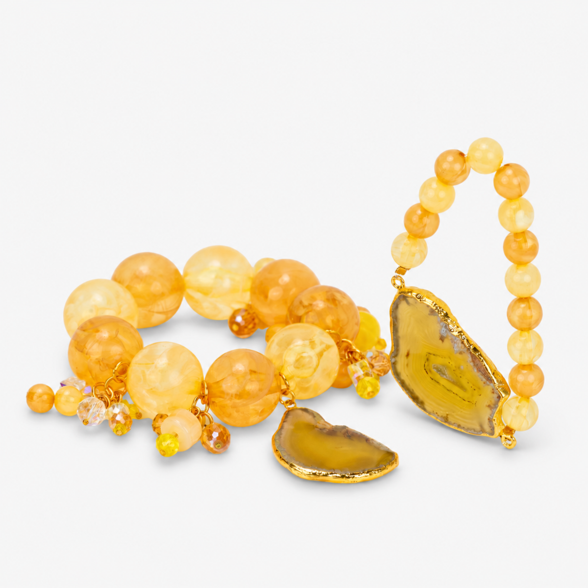 Yellow statement bracelet stack featuring oversized citrus colored beads, dangling accents, and natural agate.