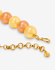 Chunky beaded necklace featuring soft yellow, peach, and cream tones with a large natural stone pendant.

Chrysallis Necklace Lemon Sorbet featuring round marbled beads, organic stone patterning, and a statement agate drop.