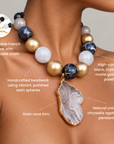 Chrysallis Black Gold necklace with alternating black, translucent, and metallic beads surrounding a sliced natural agate pendant.