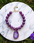 Statement necklace featuring rich grape agate beads and a natural purple druzy agate pendant edged in gold.