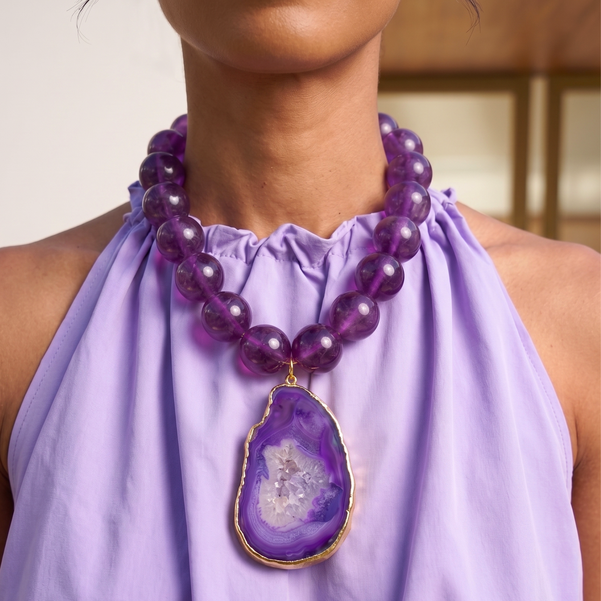 Statement necklace featuring rich grape agate beads and a natural purple druzy agate pendant edged in gold.