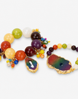 Multicolor bracelet stack featuring red, yellow, orange, purple, and rainbow beads with natural agate accents.