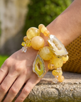 Yellow and cream marbled stretch bracelet stack featuring oversized beads, a natural agate slice pendant, and sparkling accent details by Sassy Jones.