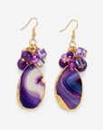 Chrysallis Natural Purple Agate dangle earrings featuring polished agate slice drops, clustered purple faceted beads and gold tone fish hook closures.