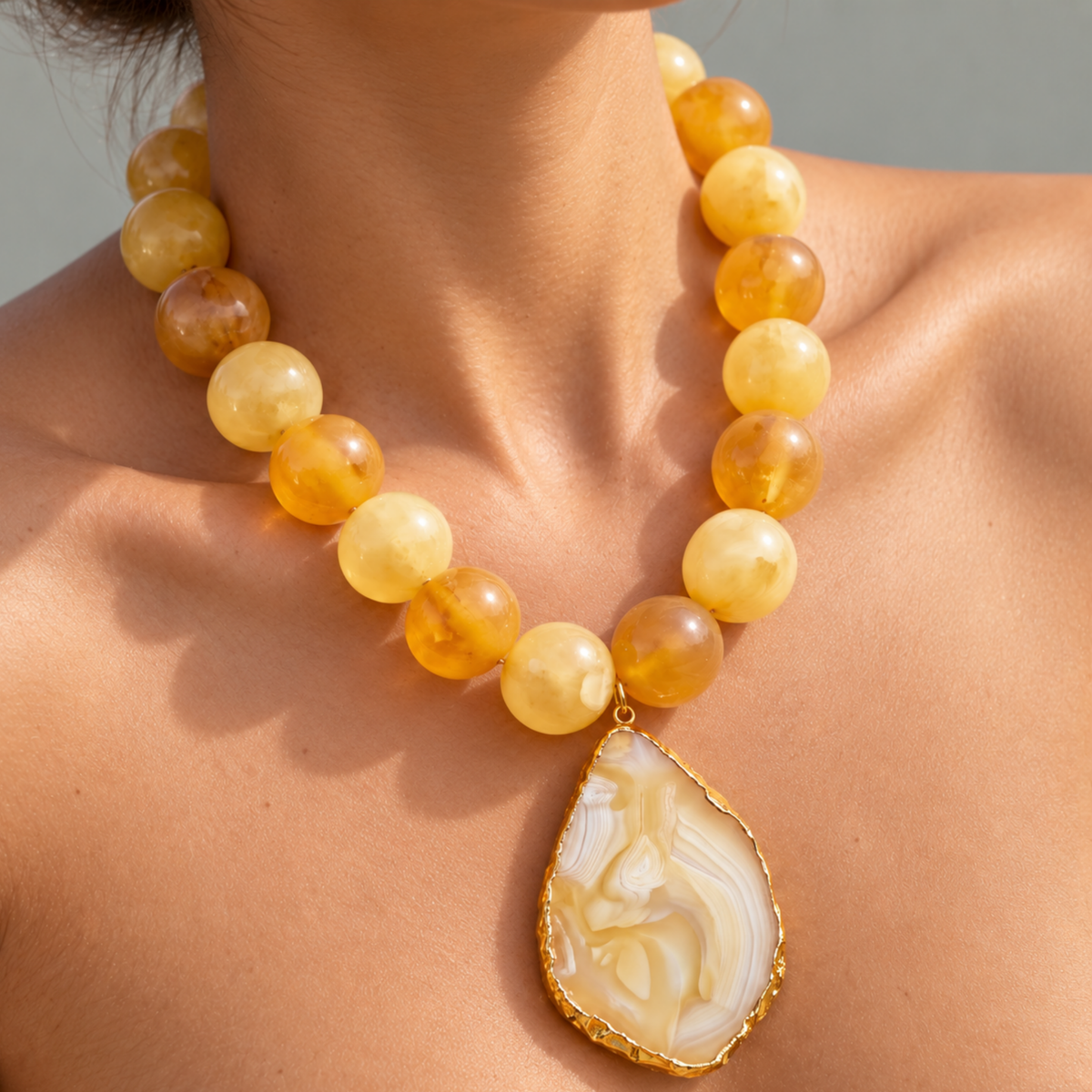 Close-up of Chrysallis Lemon Sorbet Necklace featuring a natural agate slice edged in a Gold tone finish.