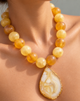 Close-up of Chrysallis Lemon Sorbet Necklace featuring a natural agate slice edged in a Gold tone finish.