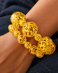 Dina Gold Openwork Sculptural Sphere 2 Piece Stretch Bracelet Stack featuring oversized and petite gold globes.
