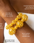 Gold statement bracelet duo featuring dimensional openwork sphere beads in mixed sizes.