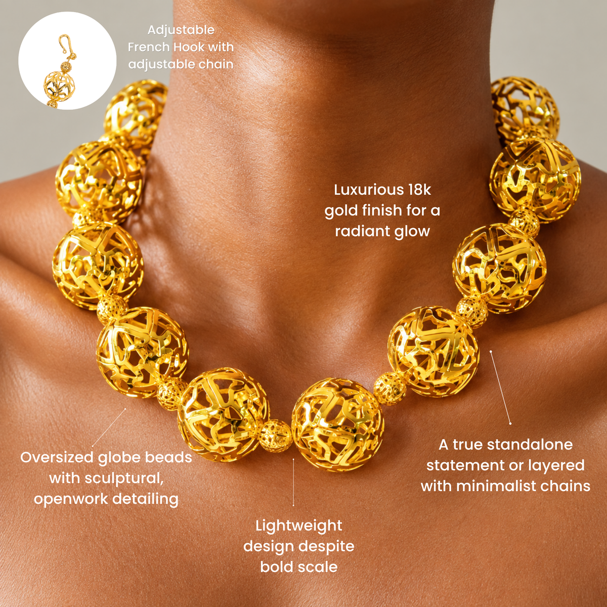 Gold statement necklace featuring large hollow globes with intricate sculptural cutout detailing.