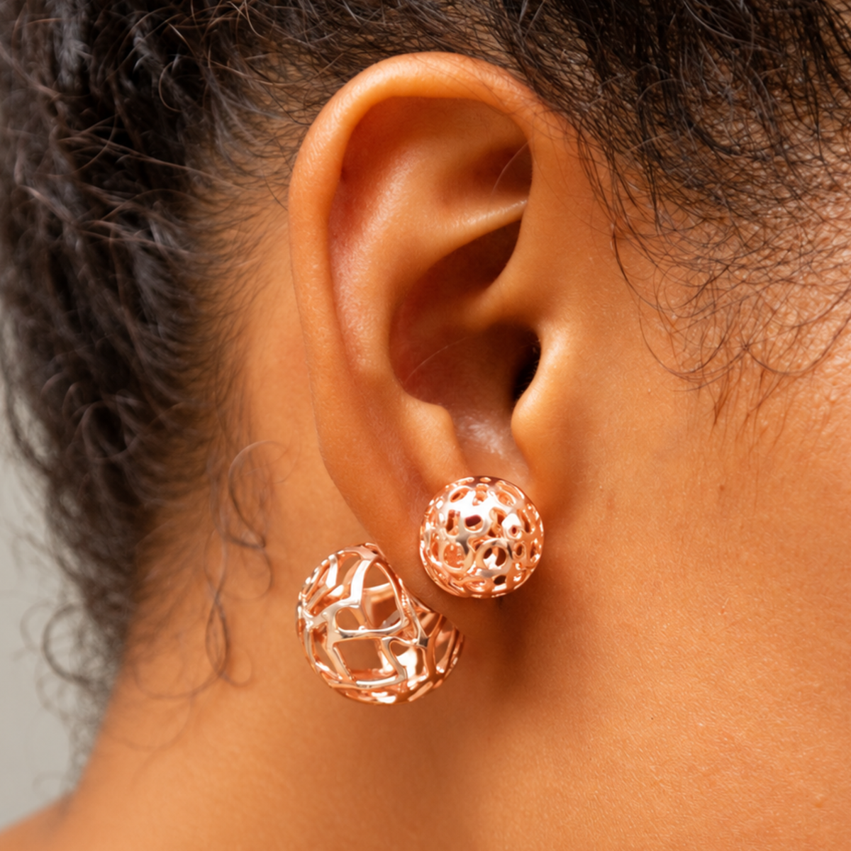 Dina Sculptural Globe Double Studs Rose Gold featuring two openwork spheres in contrasting sizes.