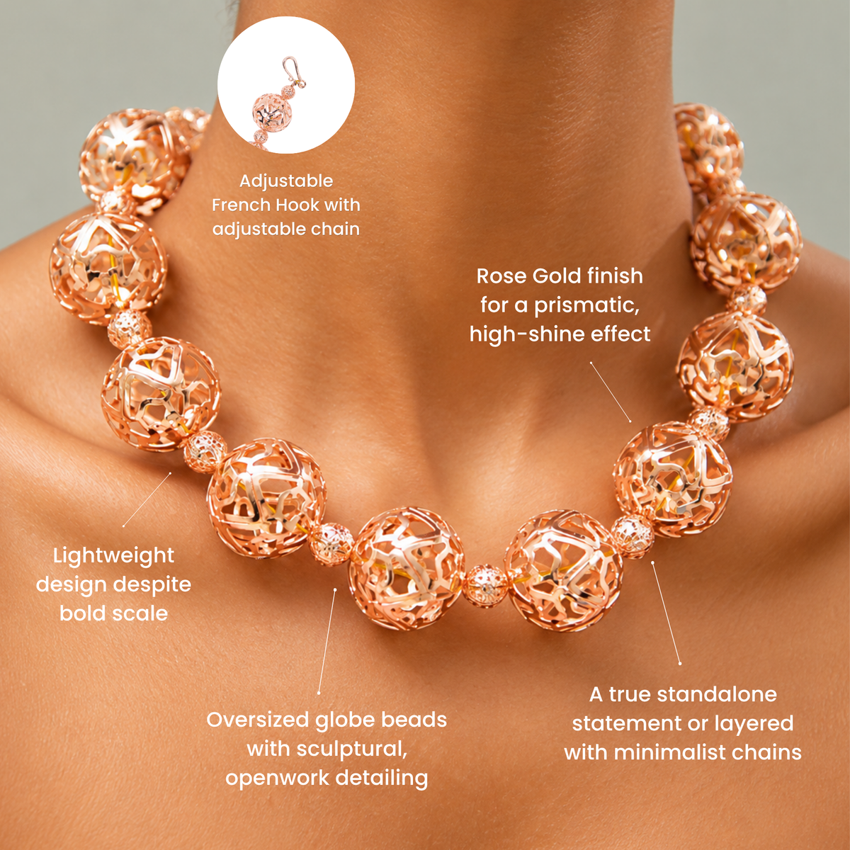Rose gold statement necklace featuring large hollow globes with intricate sculptural cutout detailing.