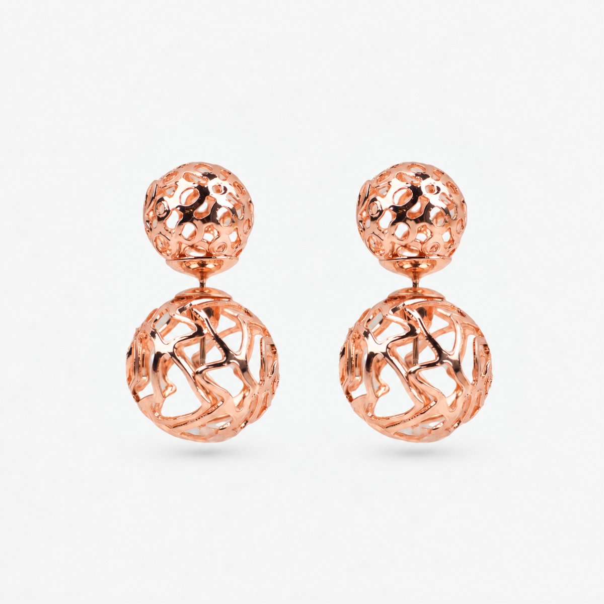 Rose gold statement earrings featuring a petite textured sphere and larger sculptural globe.