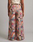 Back view of Fawna wide leg pants showcasing an allover tapestry inspired bird motif in teal, coral, pink, blue and cream.