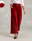 Womens red velvet wide-leg pants with scattered pearl details concentrated along the lower legs.