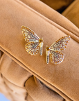 Gold butterfly stud earrings with champagne and smoky crystals in a delicate yet radiant design.