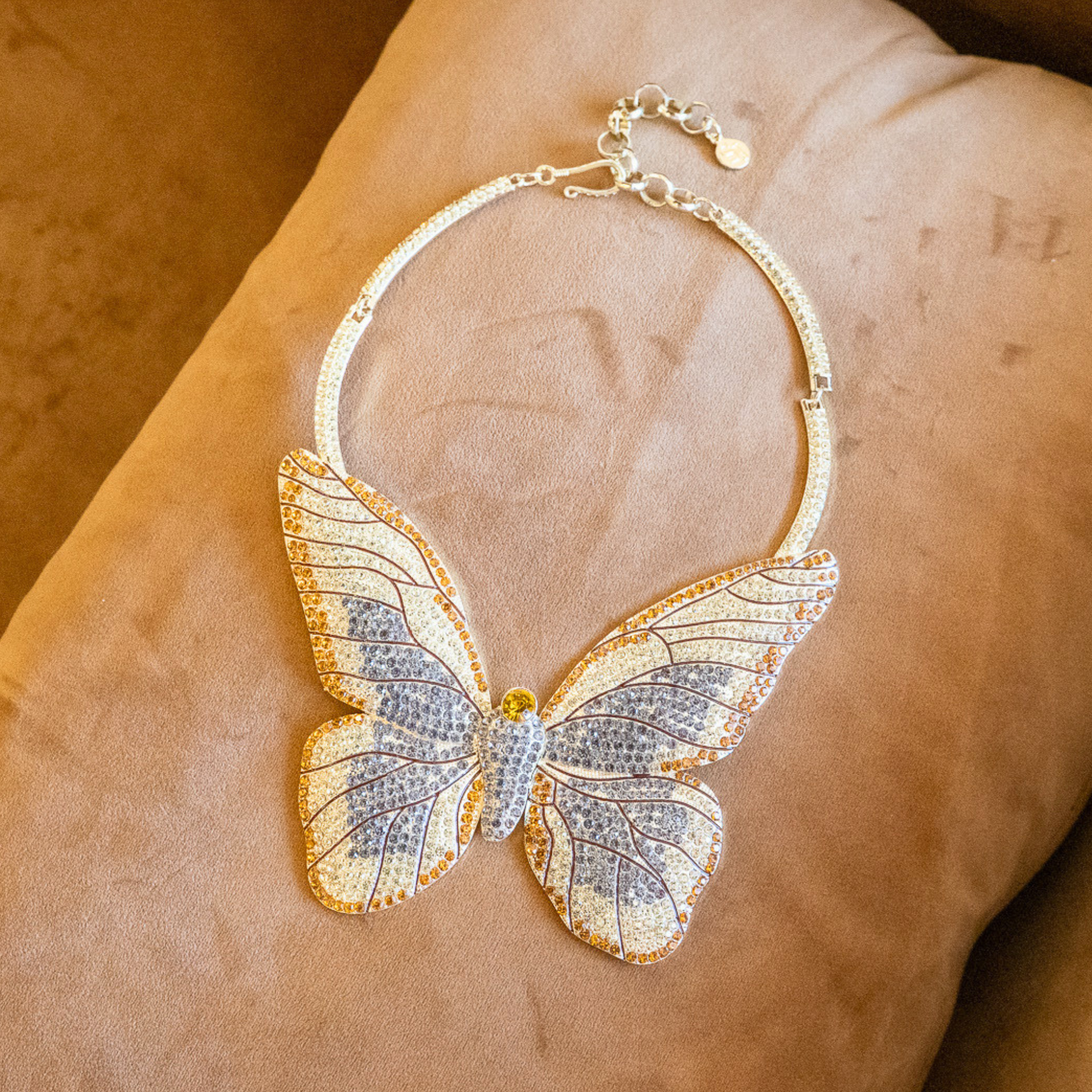 Gold butterfly statement bib necklace with champagne and clear crystals in a radiant oversized design.