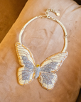 Gold butterfly statement bib necklace with champagne and clear crystals in a radiant oversized design.