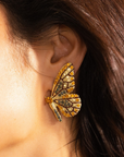 Gold butterfly stud earrings with champagne and smoky crystals in a delicate yet radiant design.