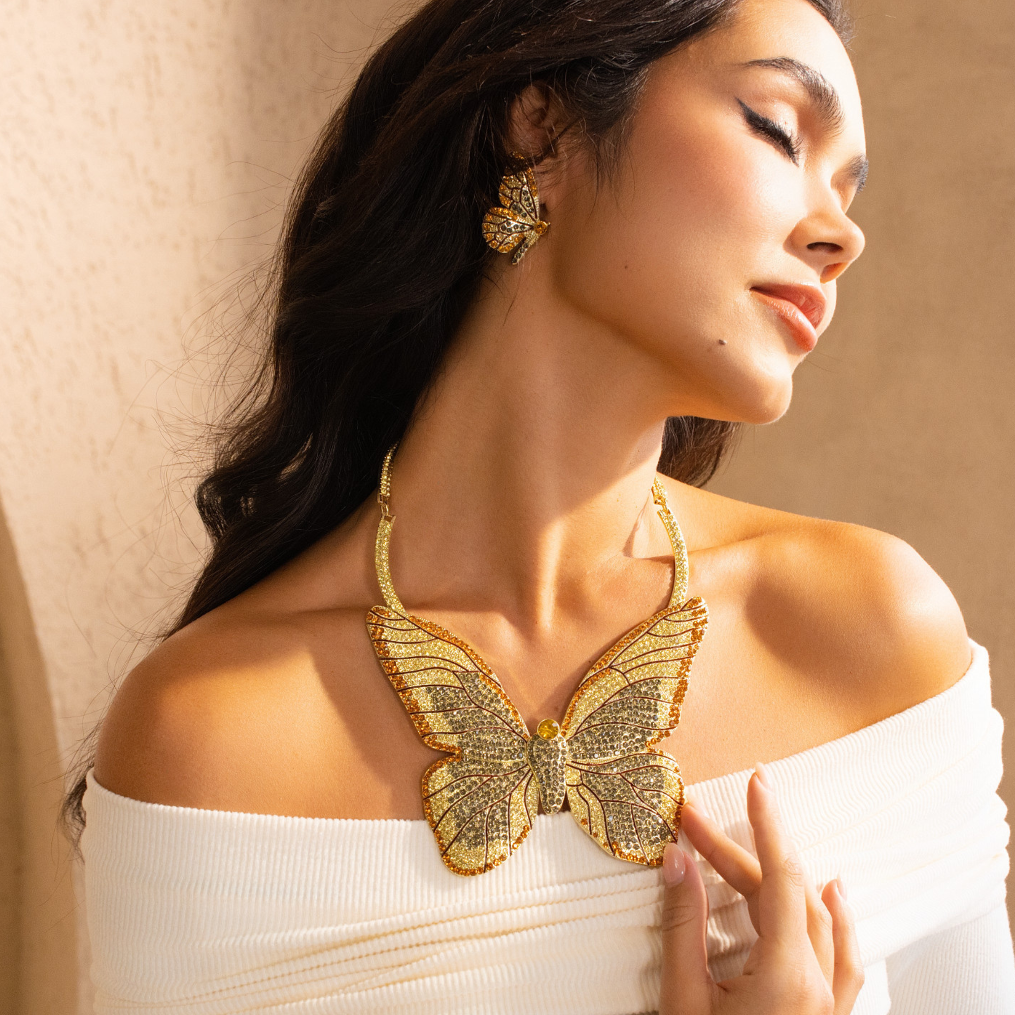 Gold butterfly statement bib necklace with champagne and clear crystals in a radiant oversized design.