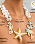 Coastal Pearl statement necklace featuring seahorse, starfish, tropical fish and anchor charms with gold details.