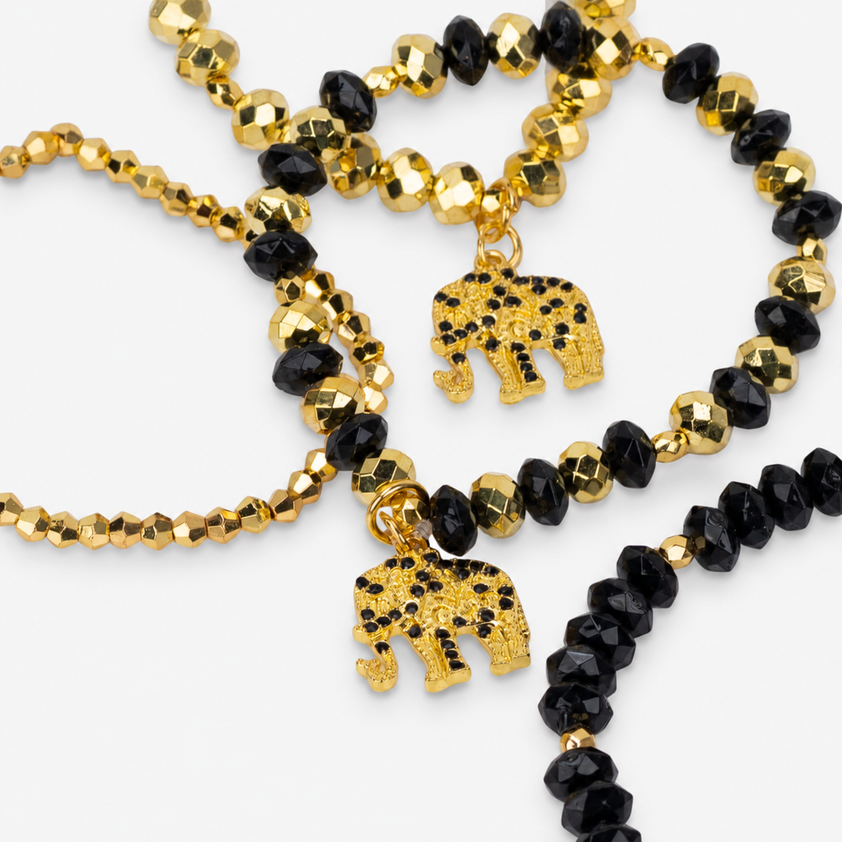 Ibiza 4pc Stretch Bracelet Stack in Black and Gold featuring faceted beads and elephant charms.
