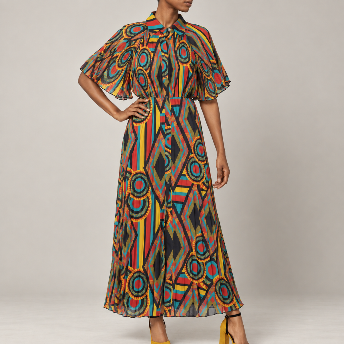 Imani Pleated Flowy Dress - Afrikaan featuring a colorful geometric print, cape sleeves, collared neckline, and flowing maxi skirt.