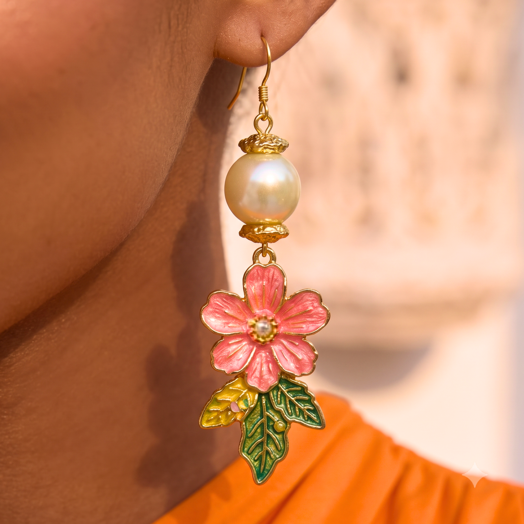 Tropical floral dangle earrings featuring luminous pearl accents, hand painted pink flowers, gold tone detailing, and lightweight drop hooks.