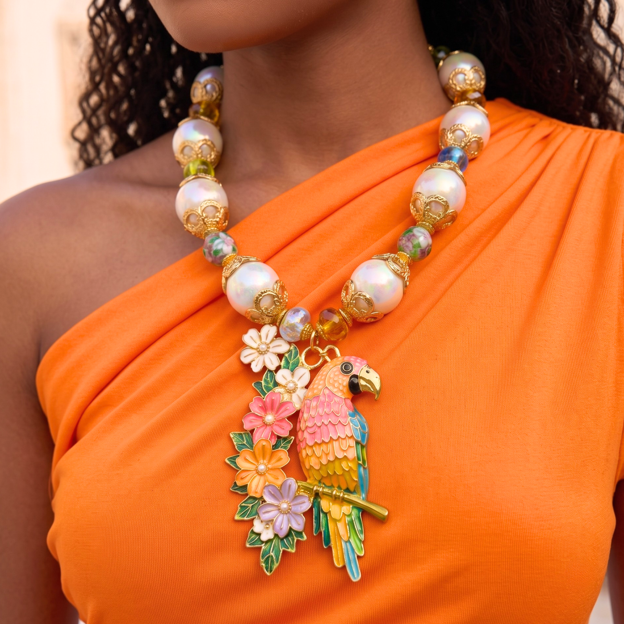 Colorful tropical statement necklace featuring luminous pearls, vibrant floral accents, artisan glass beads, and a detailed pink and gold parrot pendant.