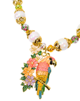 Colorful tropical statement necklace featuring luminous pearls, vibrant floral accents, artisan glass beads, and a detailed pink and gold parrot pendant.