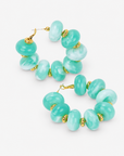 Kamaria Coconut Shell Statement Hoops in Riviera Teal featuring oversized marbled teal coconut shell pieces and gold accents.