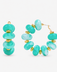 Kamaria Coconut Shell Statement Hoops in Riviera Teal featuring oversized marbled teal coconut shell pieces and gold accents.