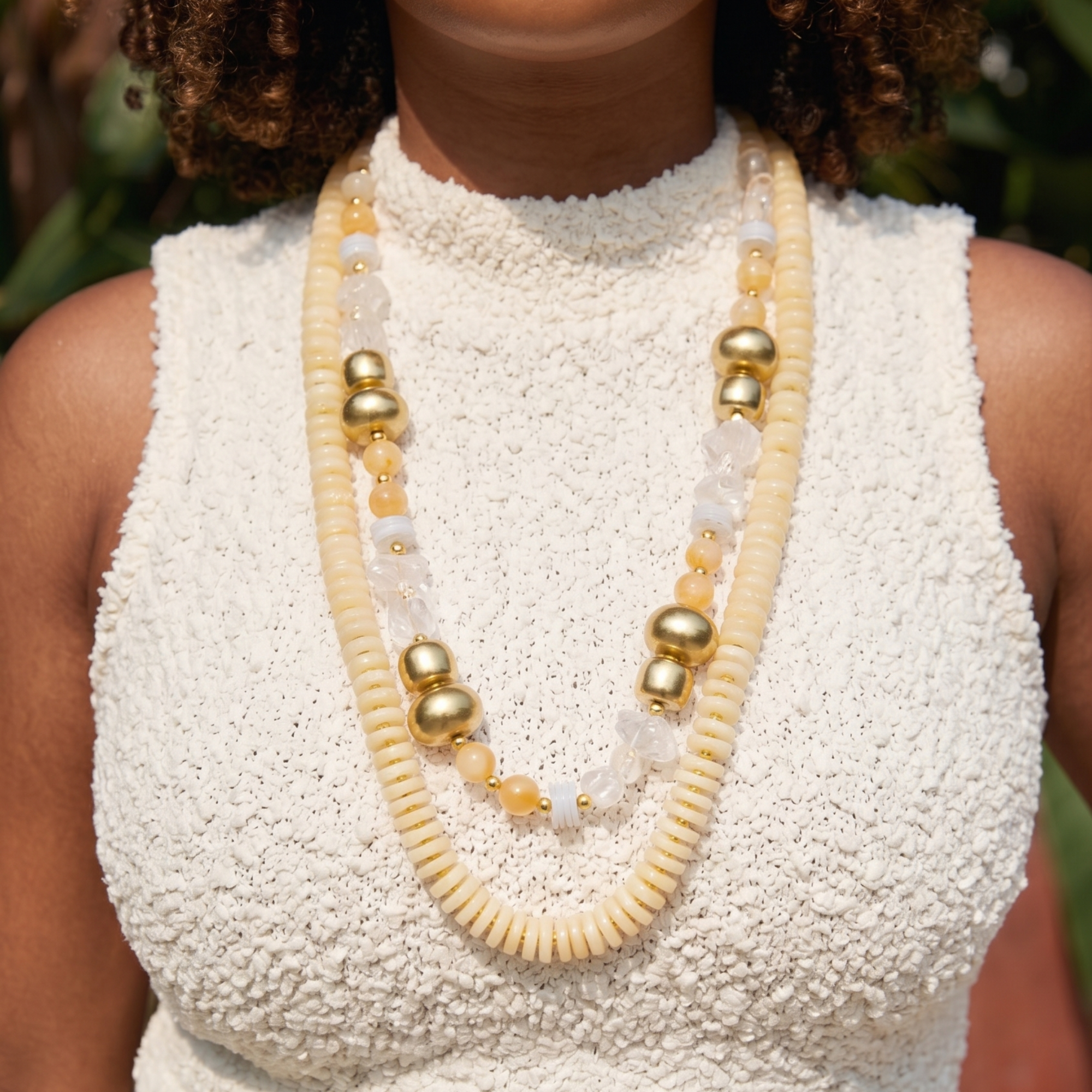 Layered ivory statement necklace featuring coconut-inspired beads, faceted clear stones, brushed gold accents, and neutral coastal styling by Sassy Jones.