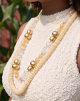 Layered ivory statement necklace featuring coconut-inspired beads, faceted clear stones, brushed gold accents, and neutral coastal styling by Sassy Jones.