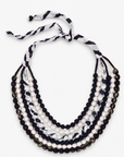 Kenza Cloth Bead Bib in black and white featuring multiple layered strands of fabric wrapped beads.
