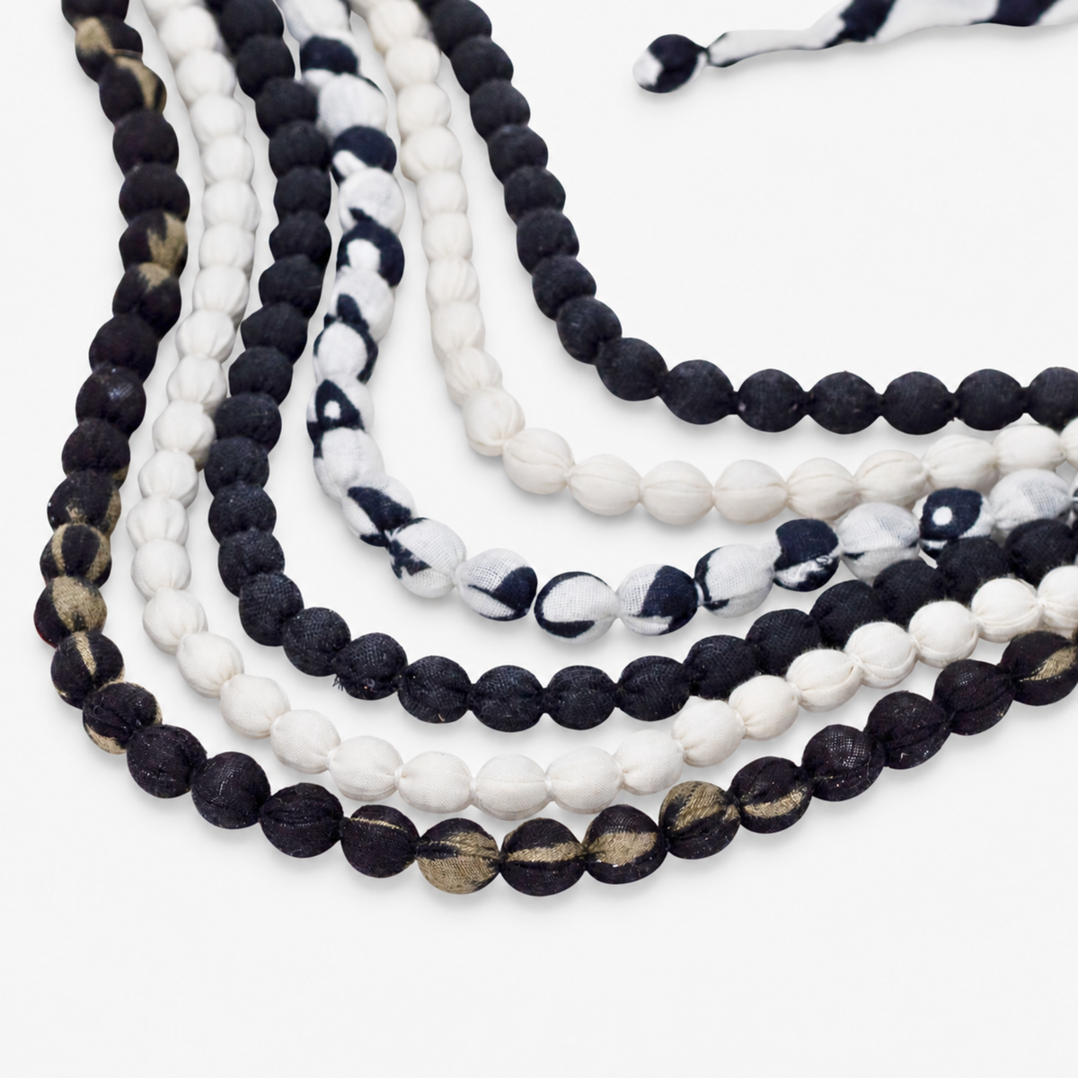 Black and white statement bib necklace with layered cloth beads and coordinating fabric tie closure.