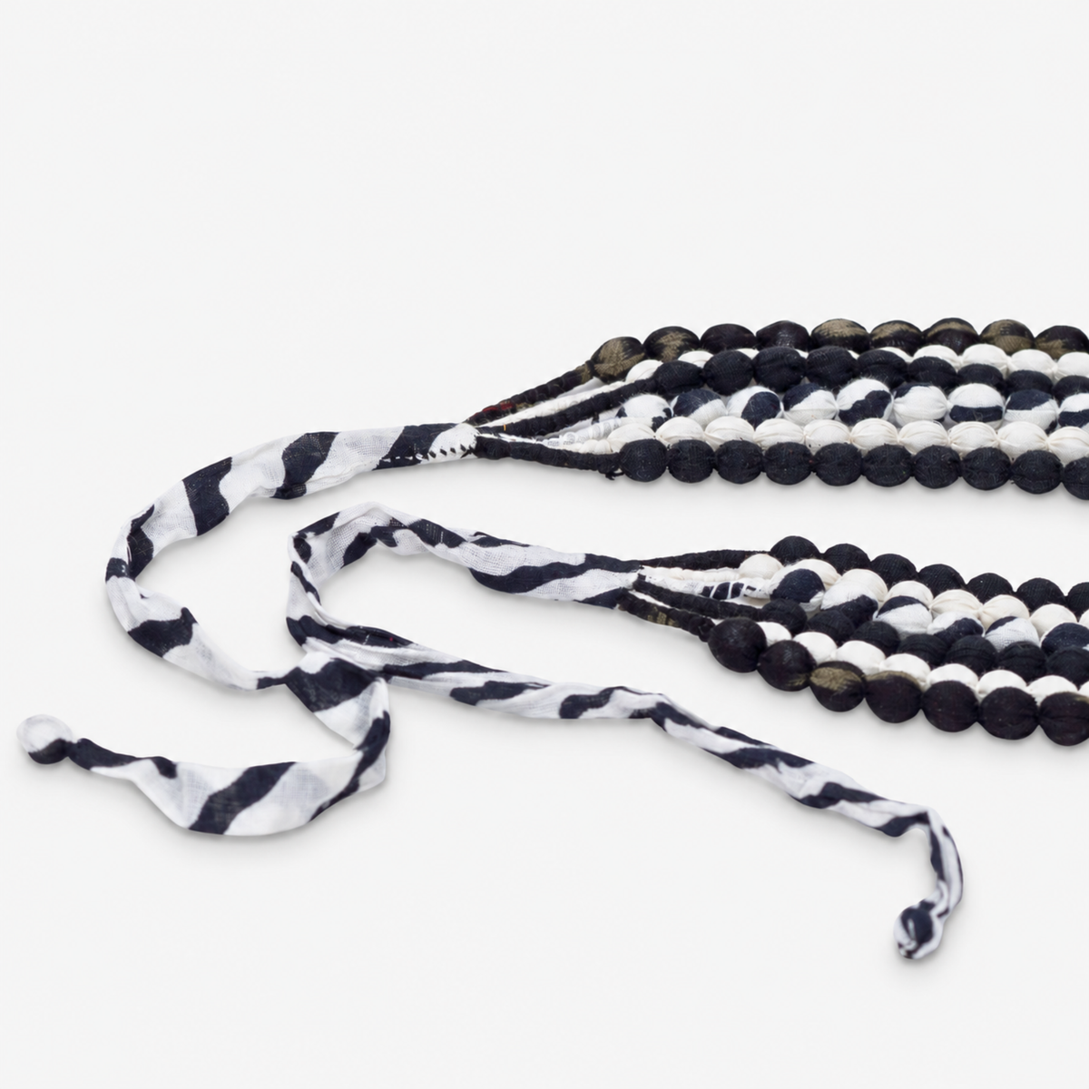 Kenza black and white statement necklace with layered textile beads and graphic monochrome pattern.