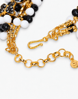 Black and white beaded bib necklace with playful removable brooch motifs and polished gold details.