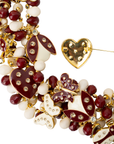 Crimson and cream statement bib necklace featuring removable butterfly, ladybug, and heart brooch charms with 18K gold-plated accents and faceted bead details.