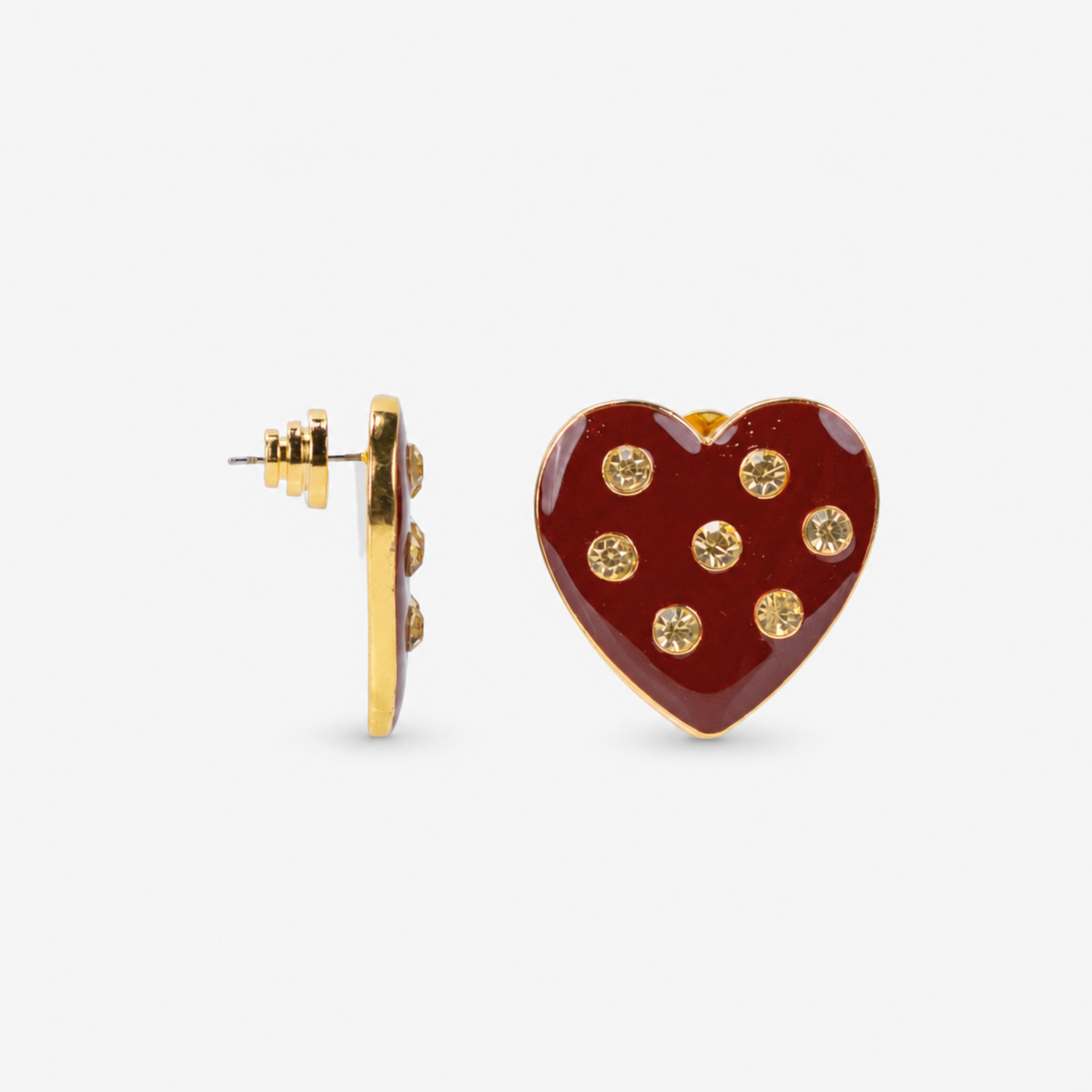 Close up of Lovebug 18K Stud showing a glossy crimson heart embellished with seven sparkling clear crystals.     Sassy Jones Lovebug heart earrings featuring rich red heart silhouettes, crystal embellishments and polished gold edging.
Oversized red heart stud earrings featuring a glossy crimson surface with clear crystals and 18K gold plated detailing.