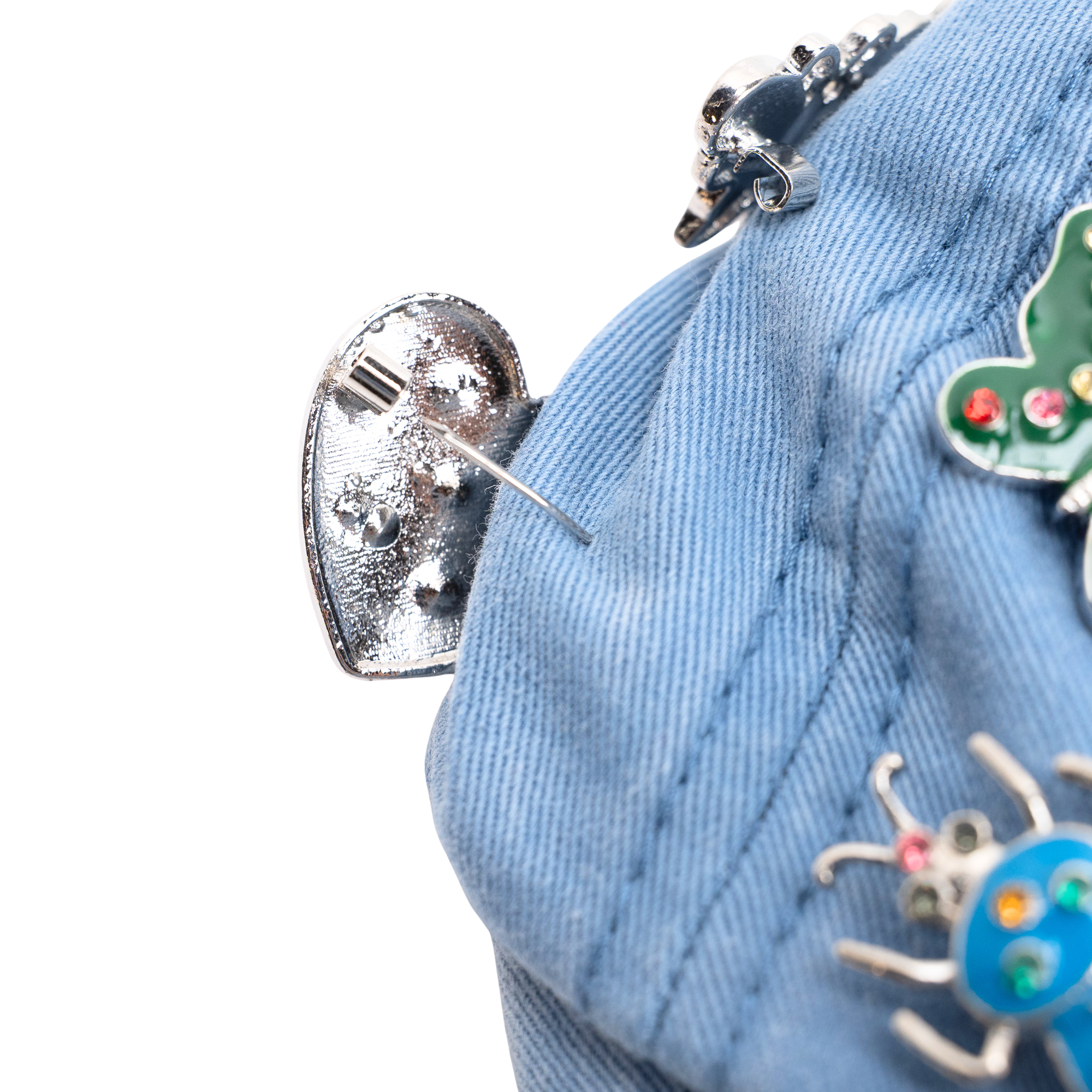 Light wash distressed denim ballcap featuring removable butterfly, ladybug, heart, and floral crystal brooch pins by Sassy Jones.